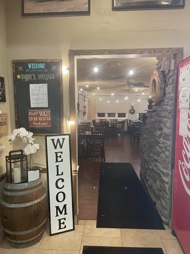 The entrance, with a welcome sign, a wine barrel and a chalkboard of the day's specials