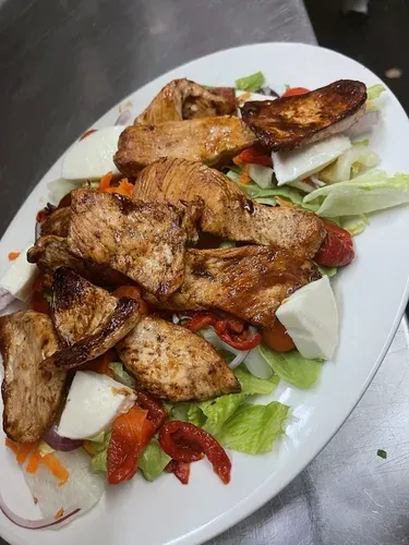 Grilled chicken over a salad with fresh mozzarella and roasted red peppers