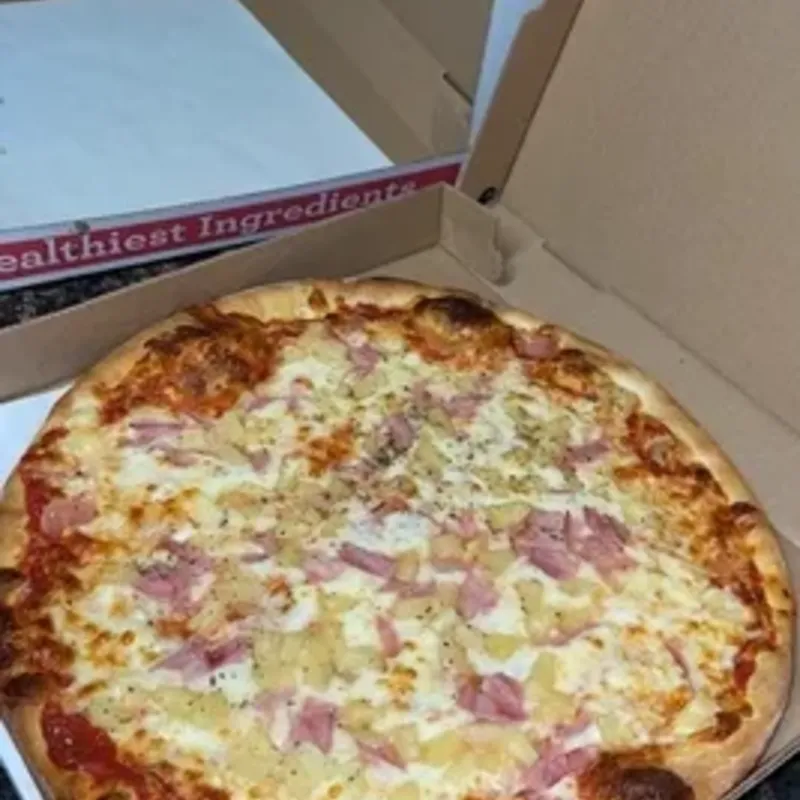 A ham and cheese pizza in an open takeout box