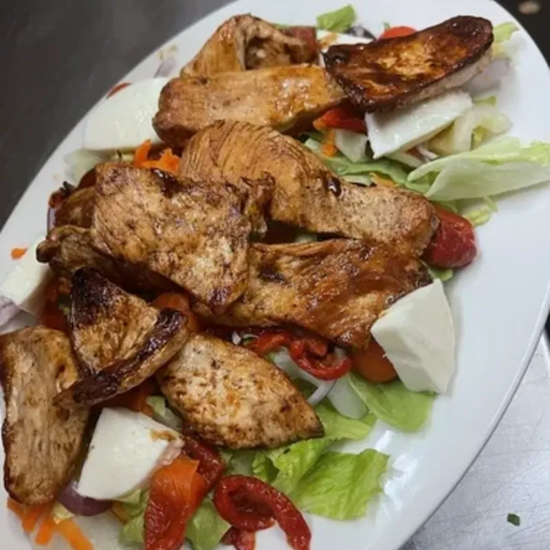 Grilled chicken over a salad with fresh mozzarella and roasted red peppers