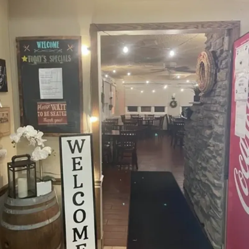 The entrance, with a welcome sign, a wine barrel and a chalkboard of the day's specials